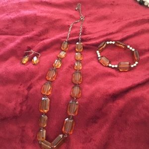A brown necklace with earrings and bracelet